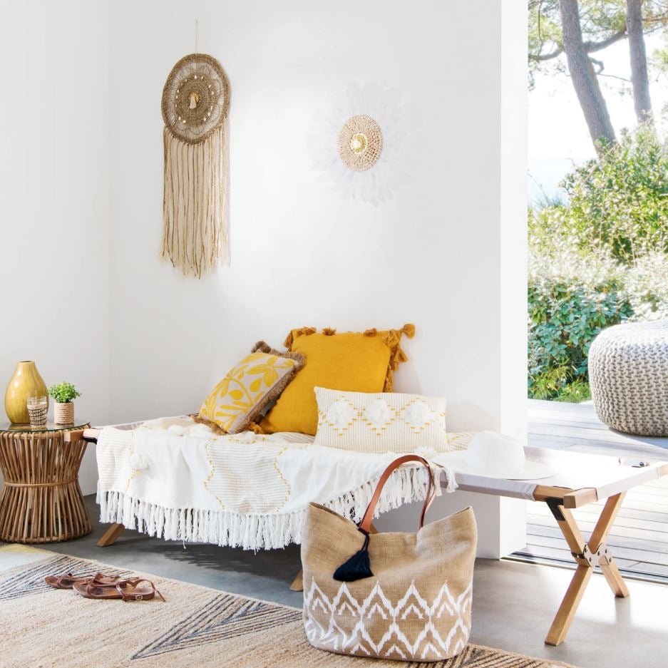 Pura esencia mediterránea en este rincón exterior que nos invita al relax con el amarillo y el blanco como protagonistas junto a los materiales naturales.