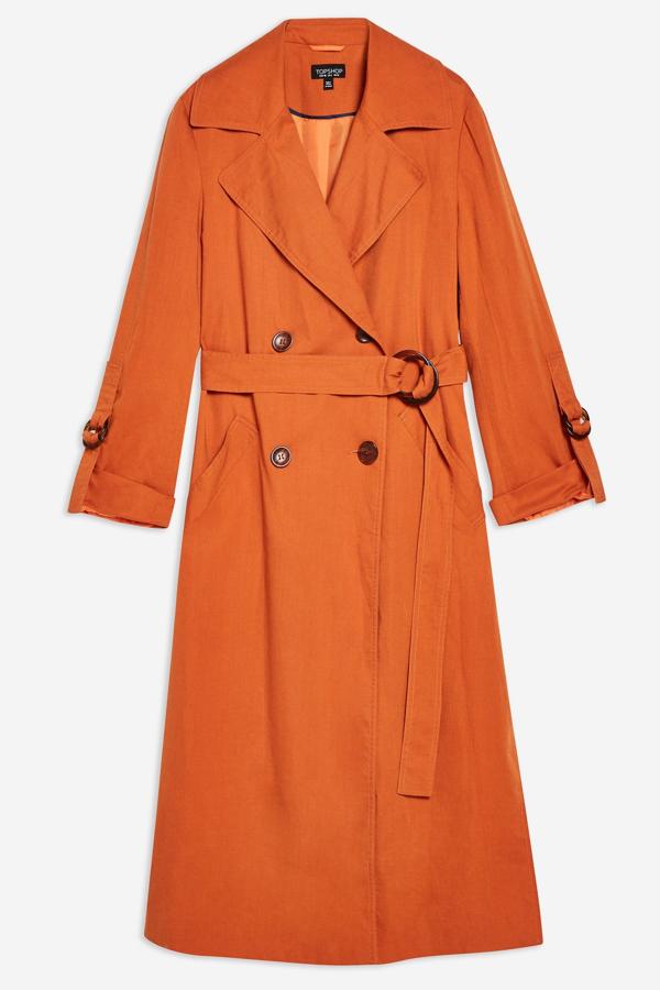 Trench con cinturón de silueta atemporal en color calabaza. (Topshop, 69 euros).