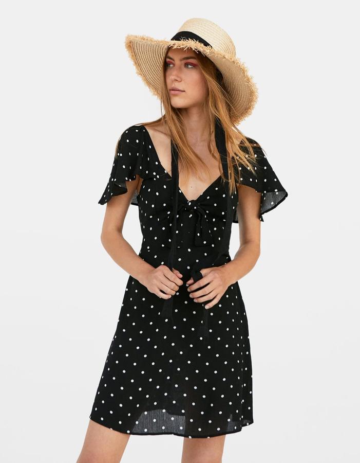 Mini vestido de lunares con escote en uve y detalle de lazo, de Stradivarius (17.99 euros).