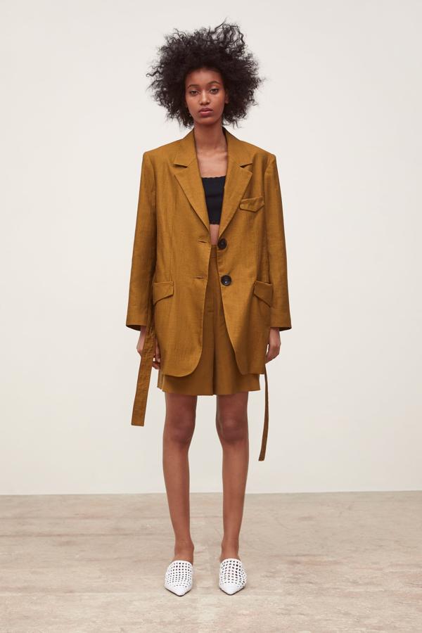 En clave 'oversize' y estética safari, otra opción brillante que nos brinda Zara es este traje en lino en color cámel. La chaqueta con cinturón cuesta 59.95 euros, y las bermudas, 25.95 euros.