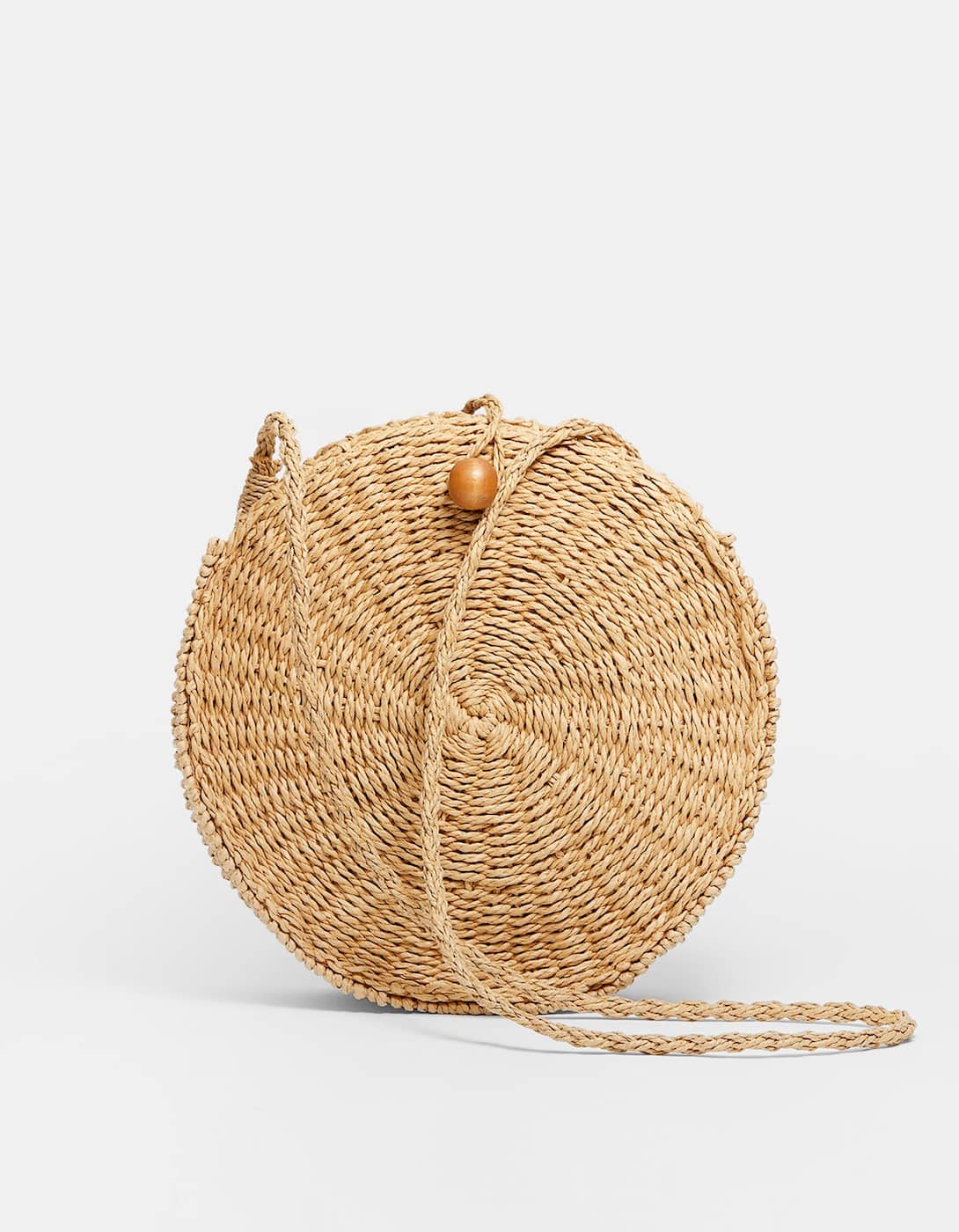 Bandolera efecto rafia con forma redonda: 29,99 euros en Stradivarius. Disponible también en negro.