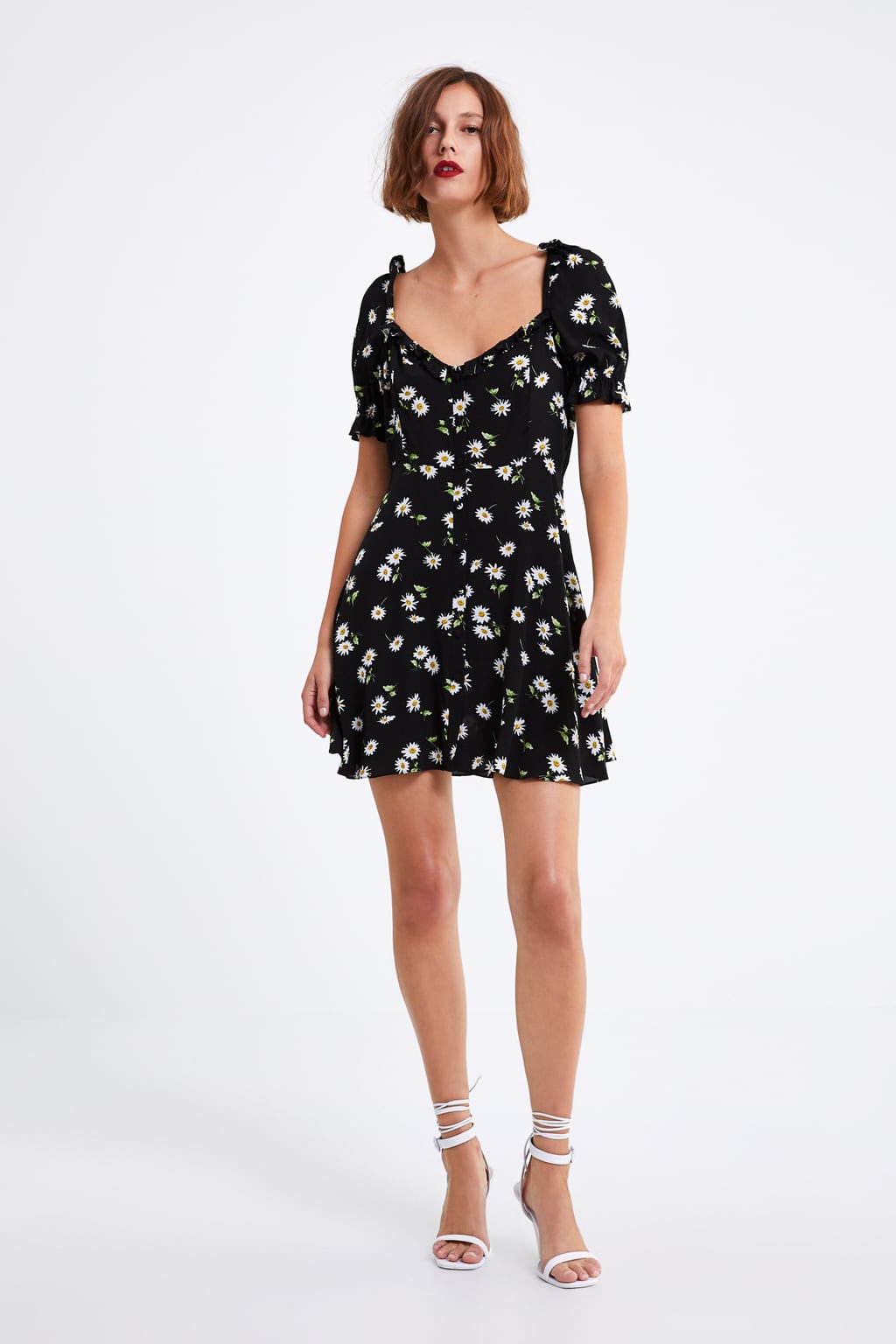 Vestido corto fluido con escote a pico y estampado floral sobre negro: 17,99 euros en Zara.