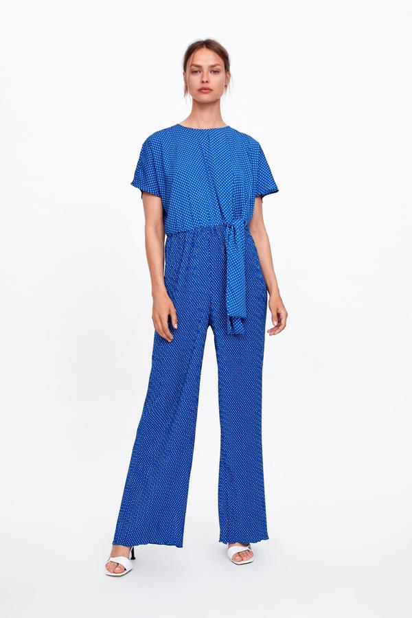 Mono azulón con estampado de lunares en blanco y detalle de lazo en la cintura (49.95 euros en Zara).