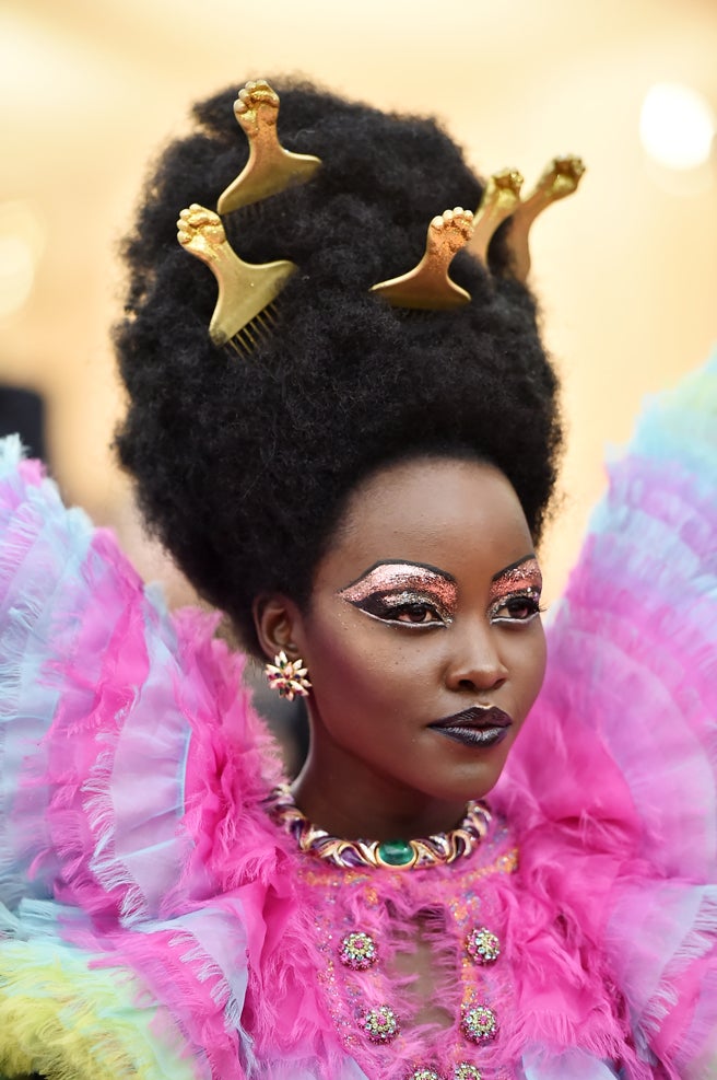 Lupita Nyong'o se tomó al pie de la letra de lo la estética excesiva. Así que la actriz combinó un vestido Versace multicolor con un maquillaje también multicolor con mucho glitter y un cardado lleno de peines dorados, obra del estilista Vernon François y del maquillador Nick Barose.