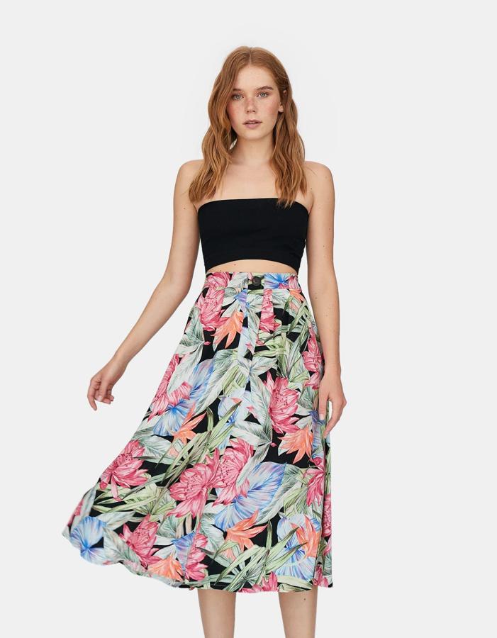 Falda de flores con fondo negro, plisada con tablas grandes, con cierre delantero de botón (25,99 euros).