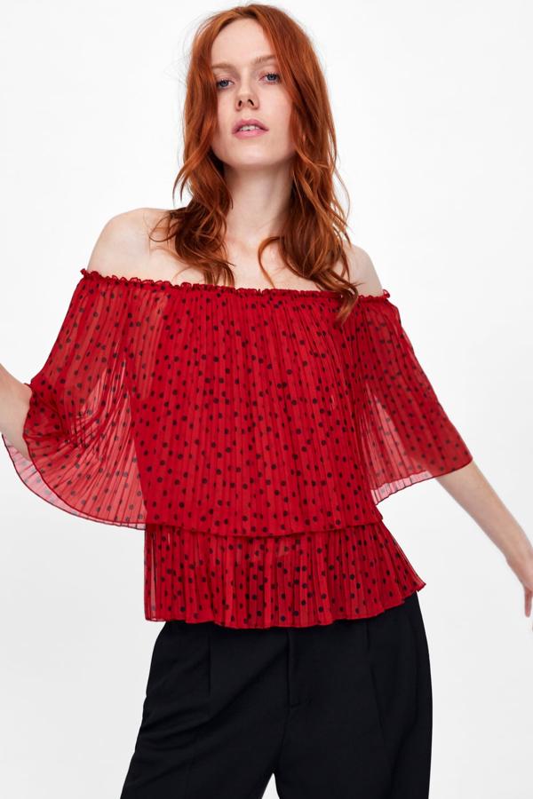 Cuerpo fluido de escote amplio con elástico y manga sisa. Lleva la aplicación decorativa de varios volantes plisados (29,95 euros).