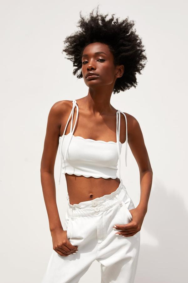 Top corto de escote recto y tirantes con lazada, decorado con acabados irregulares en forma de onda (7,95 euros).