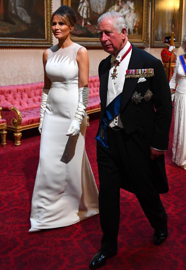 Para la cena de gala en el Palacio de Buckingham, Melania Trump nos mostró su tercer look en menos de 24 horas... y volvió a estar perfecta, esta vez con un vestido de silueta minimalista con escote fantasía de Dior, que acompañó de guantes largos también en blanco y unos stiletto de Louboutin a juego.