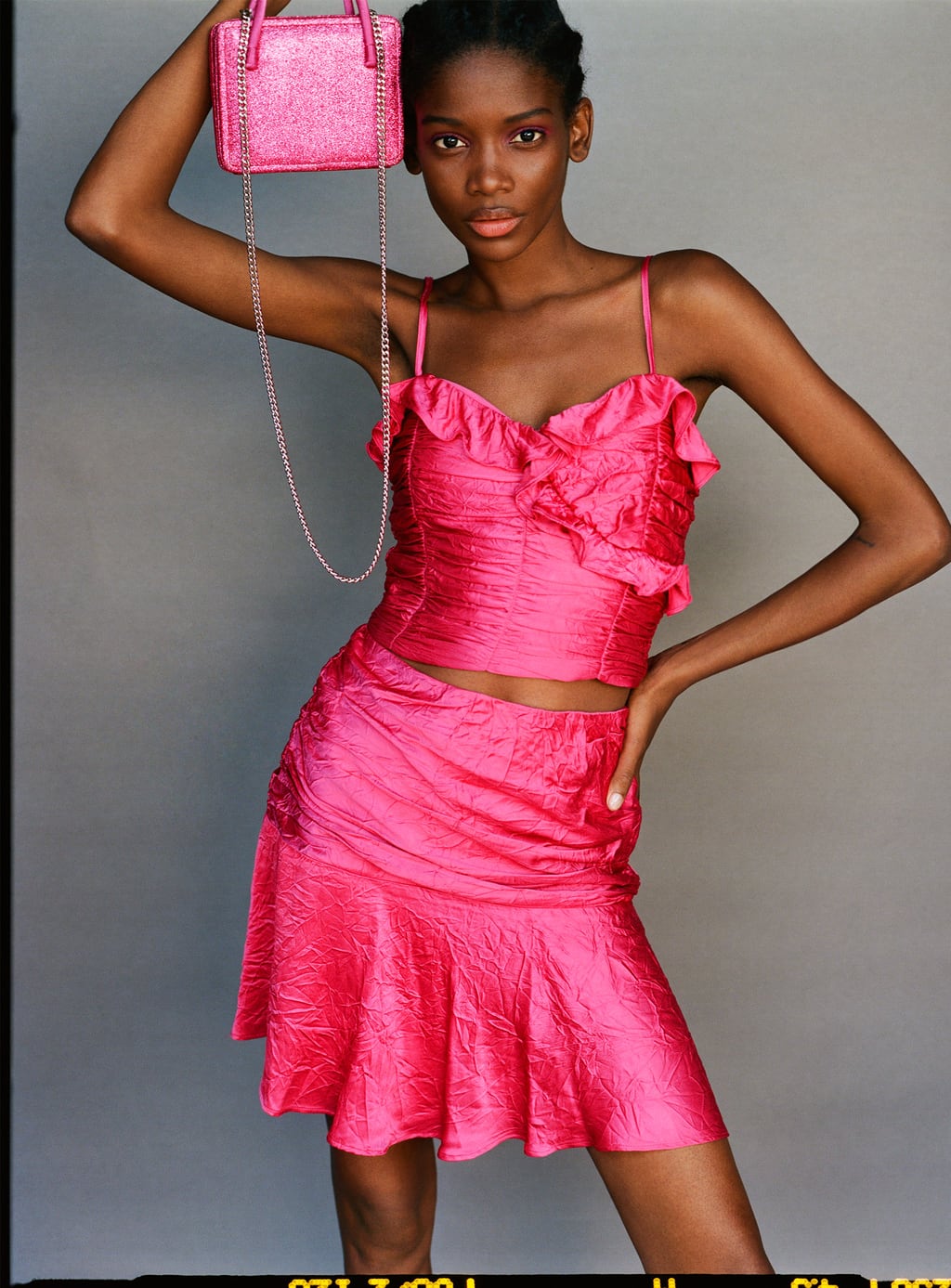 Top drapeado satinado en color fucsia: 22,95 euros en Zara y falda por 22,95 euros.