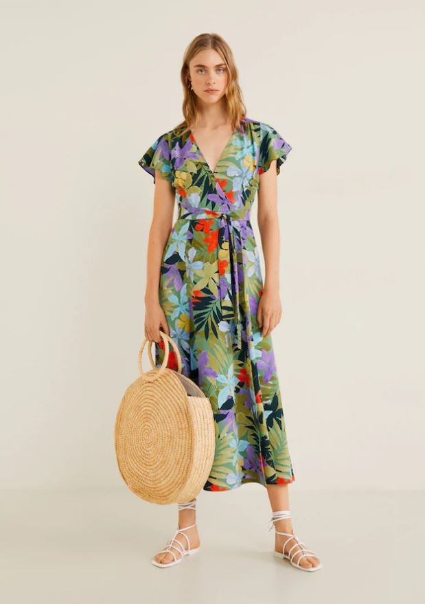 Además de hacer una silueta más estilizada con su efecto 'wrap dress', este vestido con estampado tropical de Mango potenciará tu bronceado. Precio: 49.99 euros.