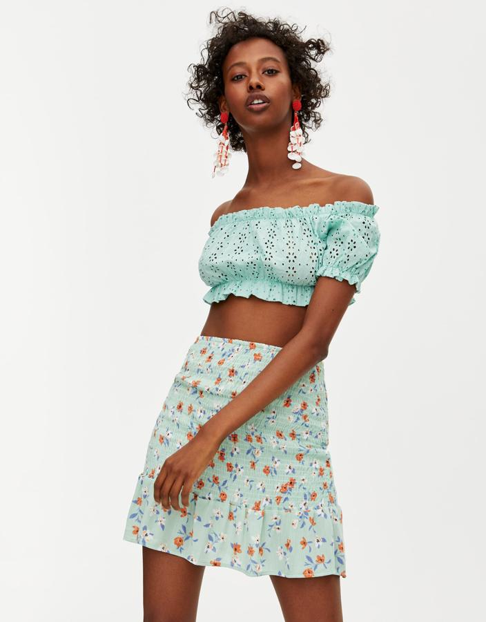 Esta temporada las minifaldas de flores han dado un giro y, como novedad, se ajustan al cuerpo con gomas.  Este modelo en turquesa es de Pull&Bear  y cuesta 15,99 euros.