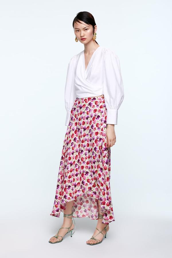 Esta falda es más fluida que con gran vuelo, pero nos ha conquistado el bajo asimétrico y la línea A que se consigue con el cierre cruzado tipo pareo. Perfecta para las que no están acostumbradas a llevar mucho volumen en la falda (Zara, 39,95 euros).