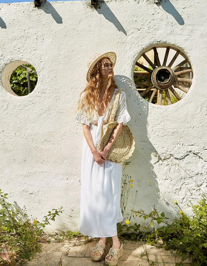 Otro vestido de Stradivarius que lo apuesta todo al romanticismo romántico, aunque esta vez remite más a un camisón. Lleva volantes, bordados suizos y un lazo en el escote de pico (29,99 euros).