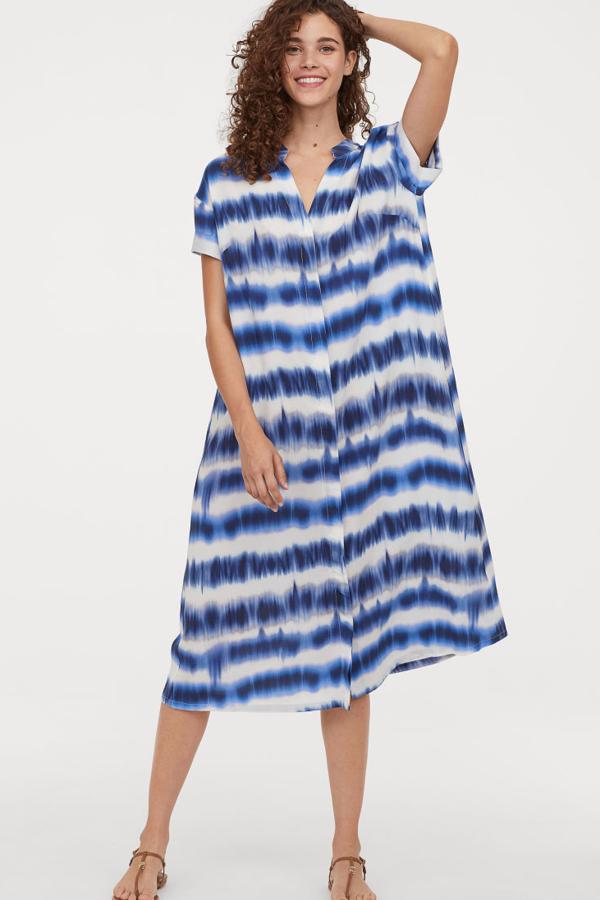 Vestido en tejido suave de viscosa con escote de pico y botones revestidos delante. Canesú con pliegue de caja en la espalda, hombros caídos y mangas cortas con dobladillo cosido. Va sin forrar (29,99 euros).