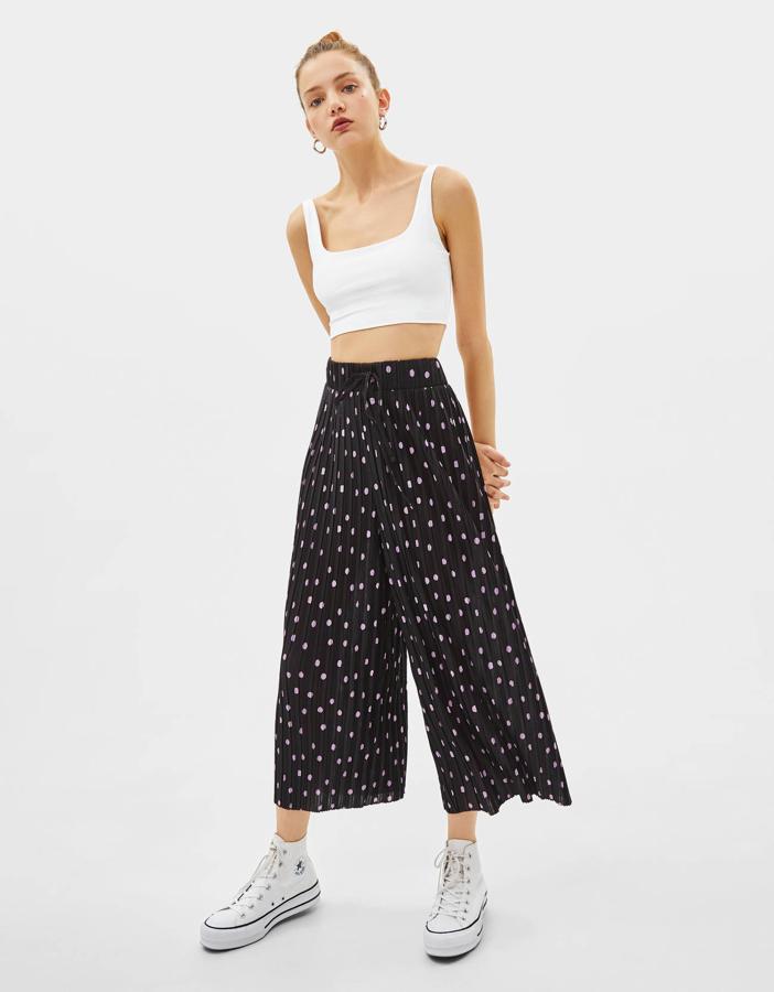 Los lunares se llevan, eso no lo discute nadie, pero si además los pantalones tienen un extra de estilo, como el plisado, ya no hay manera de resistirse a comprarlos. Y menos en rebajas. Son de Bershka y han pasado de 17,99 a 12,99 euros.