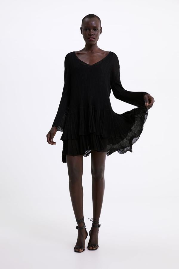 Vestido de Zara negro de punto con el bajo acabado en volantes. Cuesta 15,99 euros.