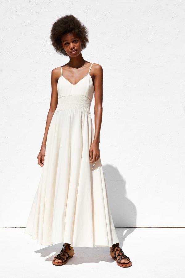 Vestido largo con escote en pico, tirantes ajustables y detalle de nido de abeja en la cintura.