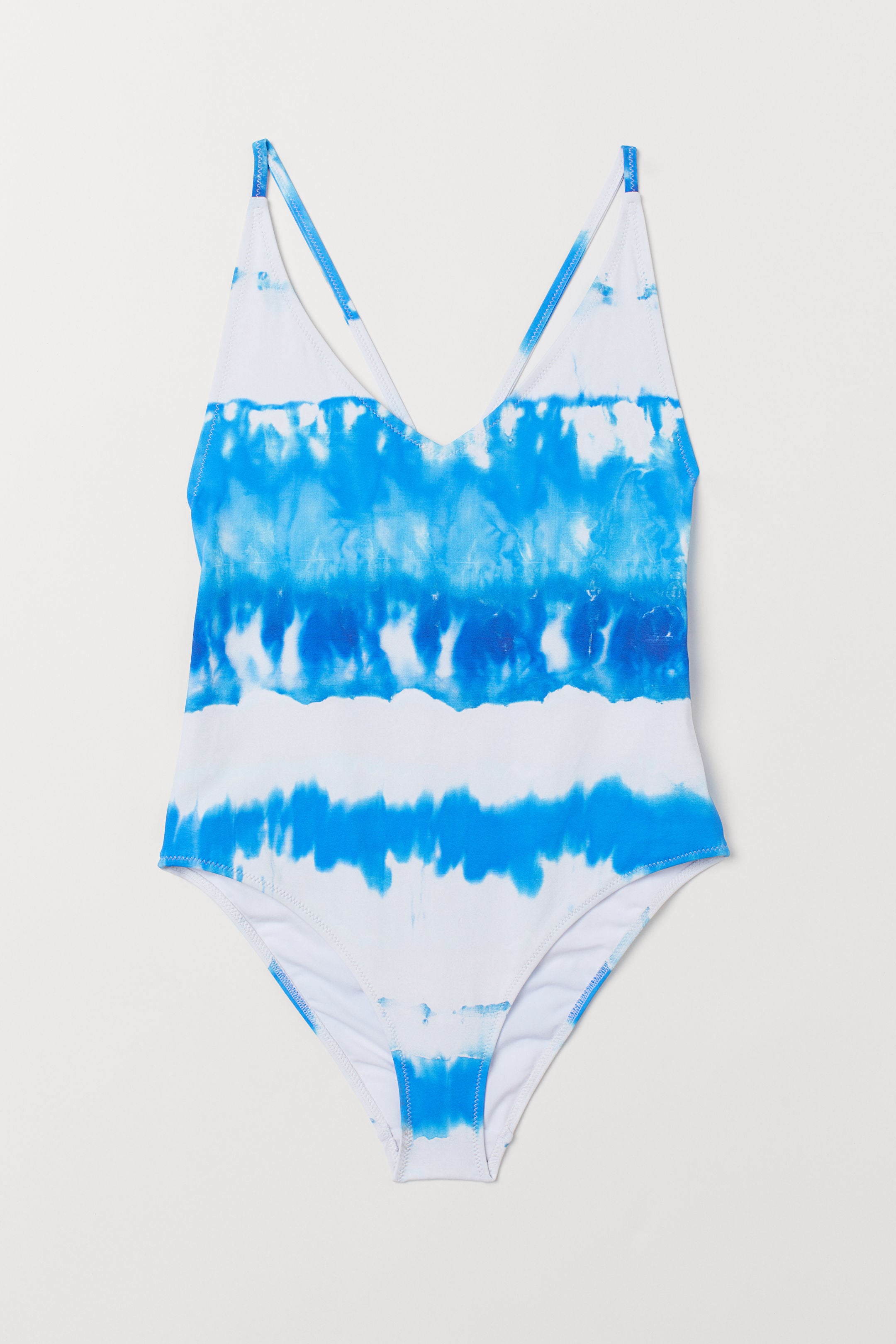 El estampado tie dye no solo es una de las tendecias estrella de la temporada, sino que es perfecto para potenciar el bronceado porque este en concreto, azul y blanco, funciona como color complementario con el tono cálido de la piel. Ficha este de H&M por 29,99 euros.