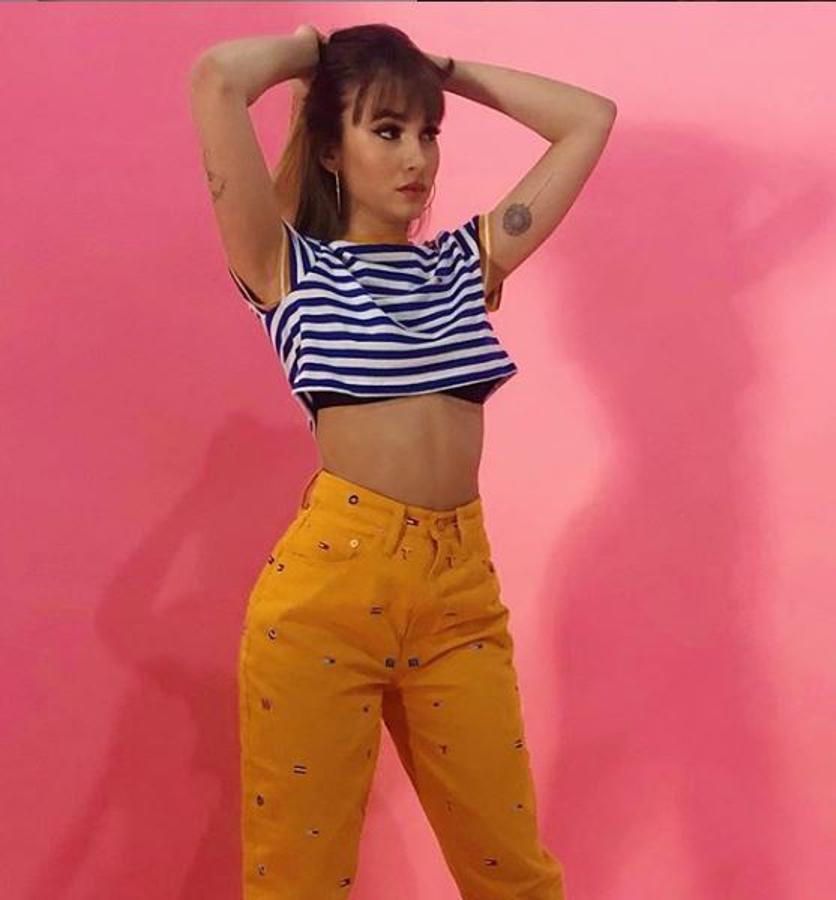 Puede que uno de sus looks más veraniegos e informales hasta la fecha. Con pantalón amarillo de cintura alta (sus favoritos) y una sencilla camiseta de rayas marineras. Todo es de Tommy HIlfiger.
