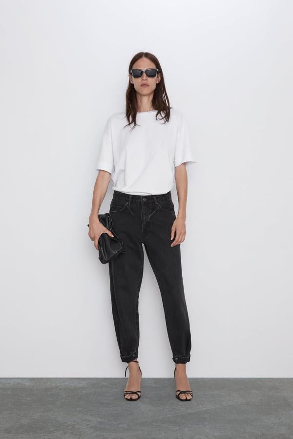 La opción más discreta de esta tendencia emergente la encontramos en estos favorecedores pantalones vaqueros negros con bajo estrecho rematado con botón de la nueva colección de Zara (29.95 euros).