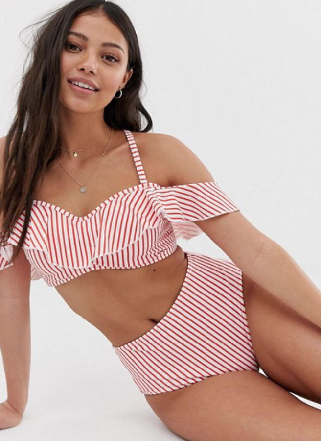 El mismo tejido a rayas rojas y blancas que lleva el bikini de Paula Echavarría, pero en una versión más decorada. Es un diseño de Freya especial para los pechos abundantes. Las braguitas de bikini son de talle alto (19,99 euros en las rebajas de Asos) y el top lleva aros, escote Bardot y un volante decorativo (24,99 euros).