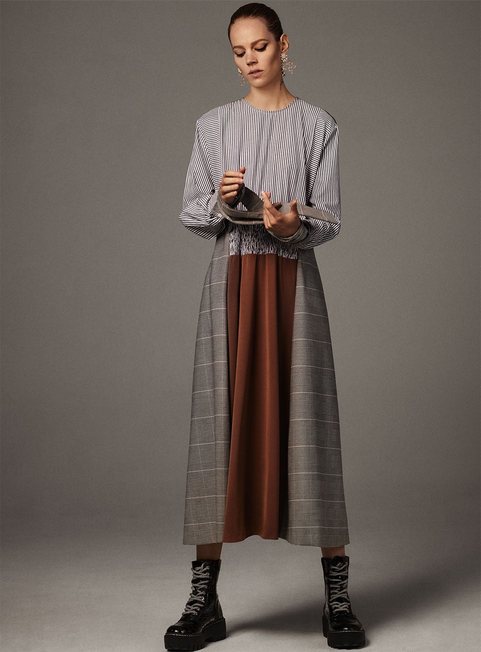 El vestido midi con mix de estampados de la nueva colección de Zara cuesta 29.95 euros, los botines, 39.95 euros y los maxi pendientes, 12.95 euros.