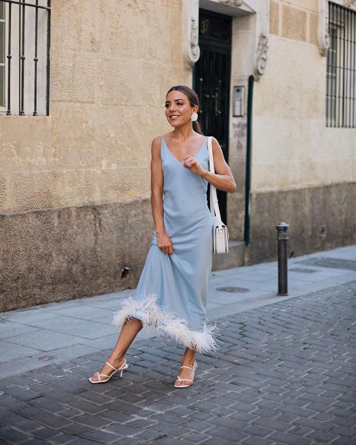 Ordovás no dudó en hacerse con las famosas sandalias blancas de Zara y las conjuntó así de bien con un vestido satinado azul bebé con plumas en el bajo.