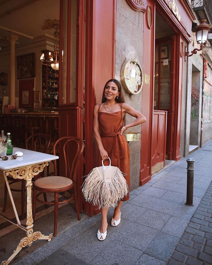 El bolso viral de Jacquemus que hemos visto su copia en algunas tiendas low cost ha sido uno de los favoritos de Paula Ordovás, que lo conjuntó este vestido satinado marrón y sandalias de Jimmy Choo.