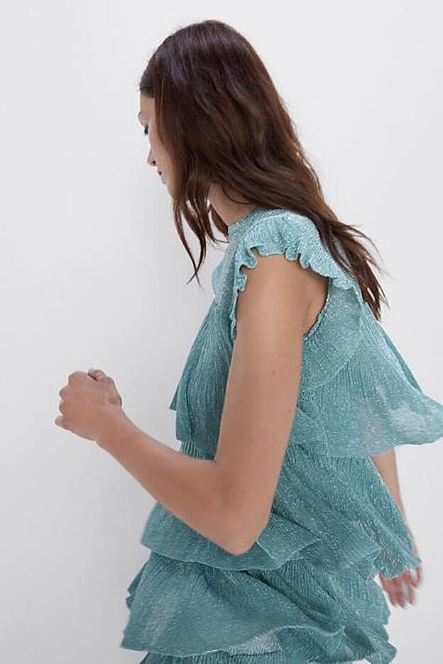 Top con hilo metalizado de cuello redondo y manga sisa con detalle de volantes , 25,95 euros.