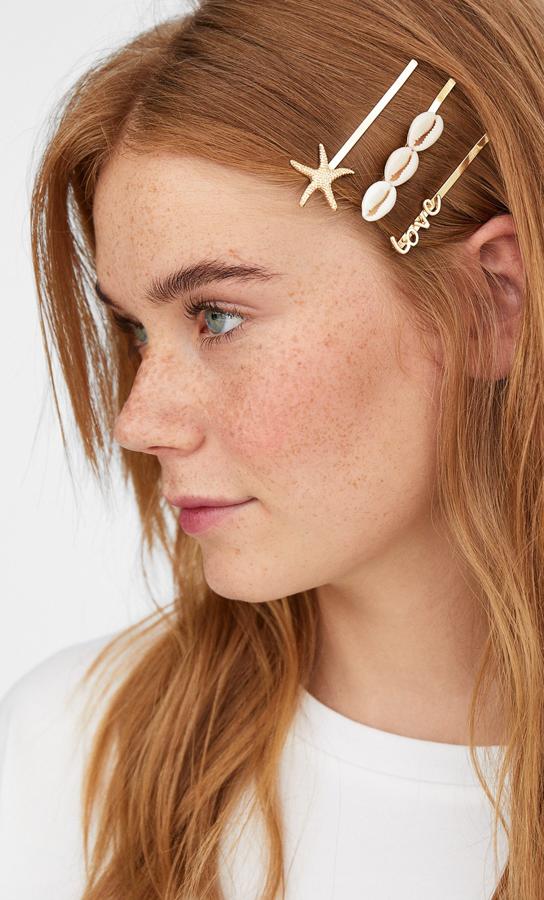 Después del boom de las horquillas de perlas ha llegado el de las de cochas y estrellas de mar. Estas de Stradivarius te ayudarán a domar tu melena de playa a la vez que suben el nivel fashion de tu look. Cuestan 5,99 y vienen tres en el mismo pack.