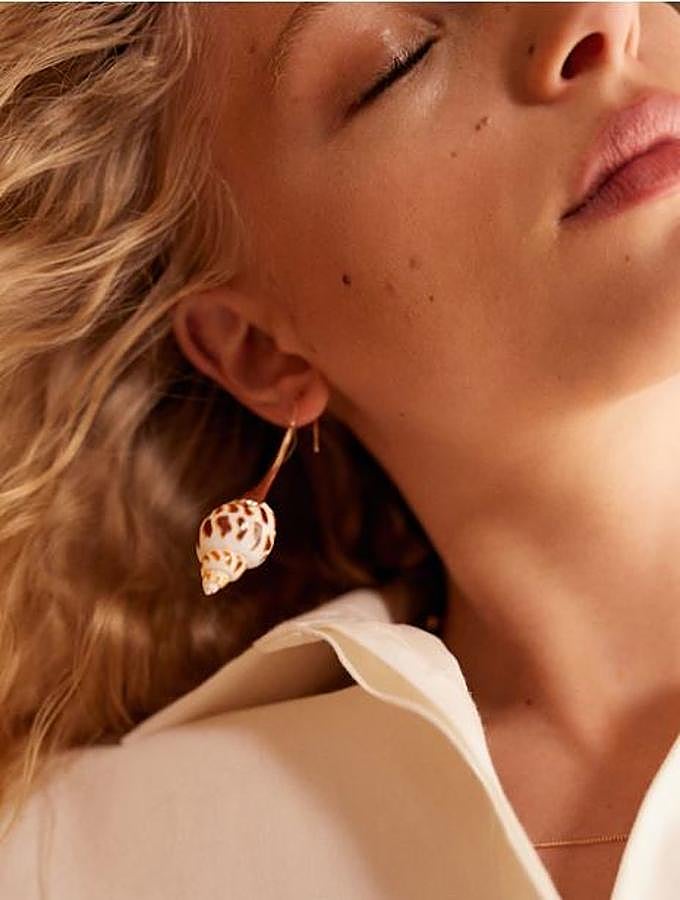 Si estás buscando algo más sofisticado, los pendientes de concha o caracolas en versión top, como estos de Mango, serán tus mejores aliados. Y no solo para la playa, los puedes llevar también en tus looks de noche. Estos son 12,99 euros.