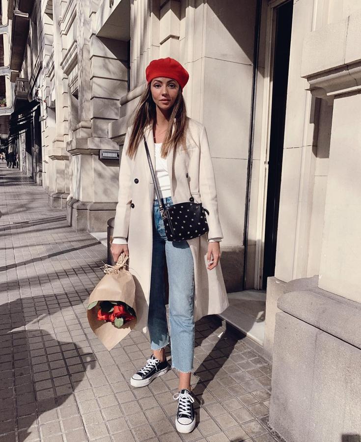 Con la boina roja, Aretha Fusté dio vida a un look de básicos compuesto por un jean recto, abrigo beige y zapatillas Converse negras.