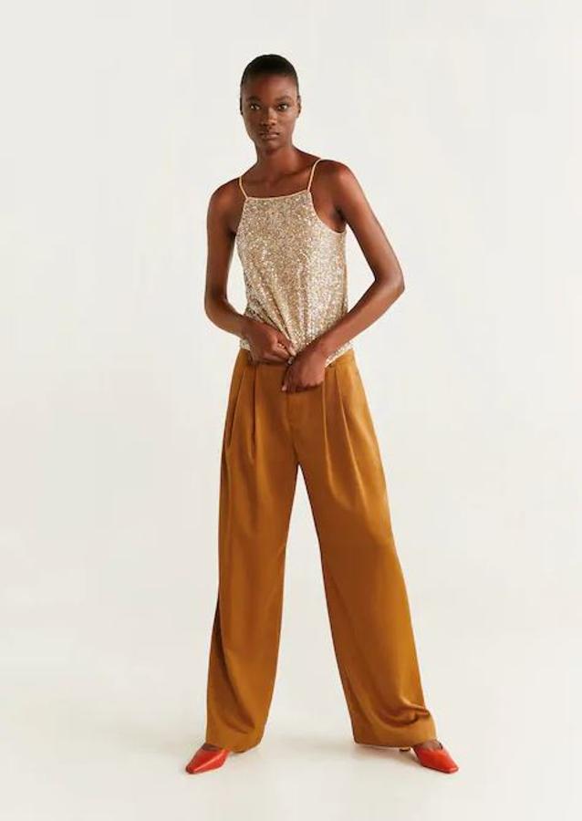 Para un look de invitada o para ir a la oficina, los pantalones palazzo siempre son elegantes y estos de Mango están disponibles en dos colores: mostaza y beige (49,99 euros).