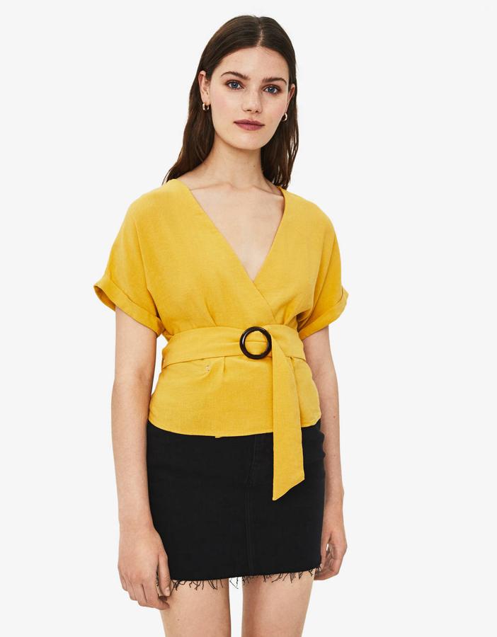 Esta es una de las prendas estrella de esta selección de rebajas de Bershka. Un top de manga corta amarillo con cinturón que está rebajado a 13,99 euros y también lo puedes encontrar en blanco.