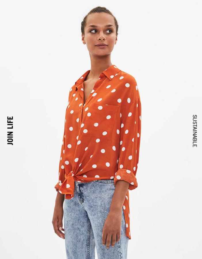 Los lunares siguen siendo tendencia y en invierno puedes seguir llevándola con esta camisa naranja que cuesta 16,09 euros.