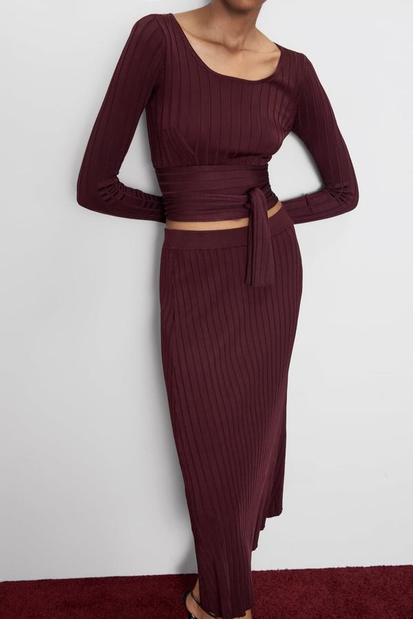 Top canalé con detalle de lazada, cuello redondo y en color burdeos, 25,95 euros.