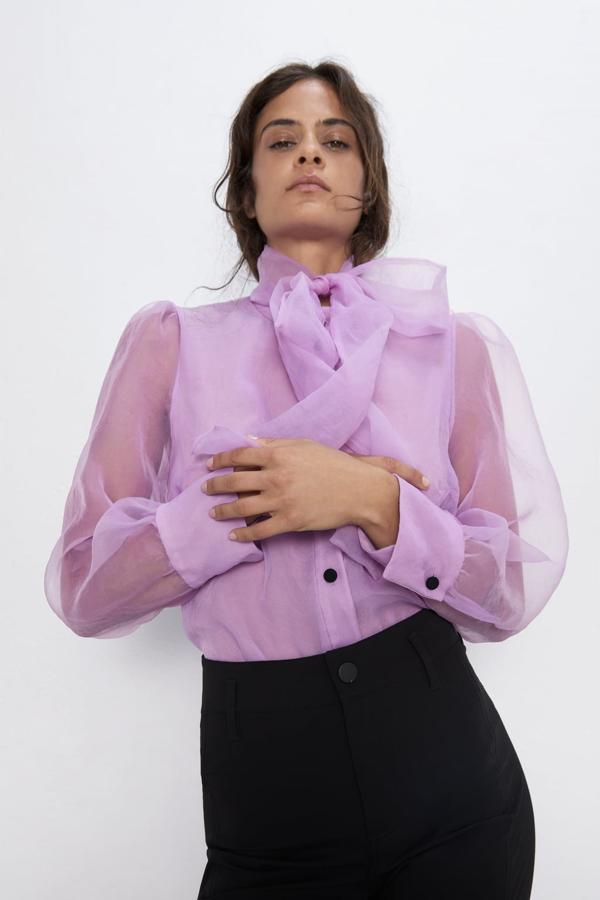 Blusa semitransparente con cuello subido, detalle de lazo, manga larga abullonada y botones, 29,95 euros.