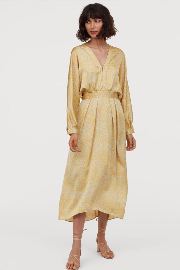 Las prendas de satén siguen siendo tendencia en otoño y este vestido midi amarillo es de H&M y cuesta 59,99 euros.