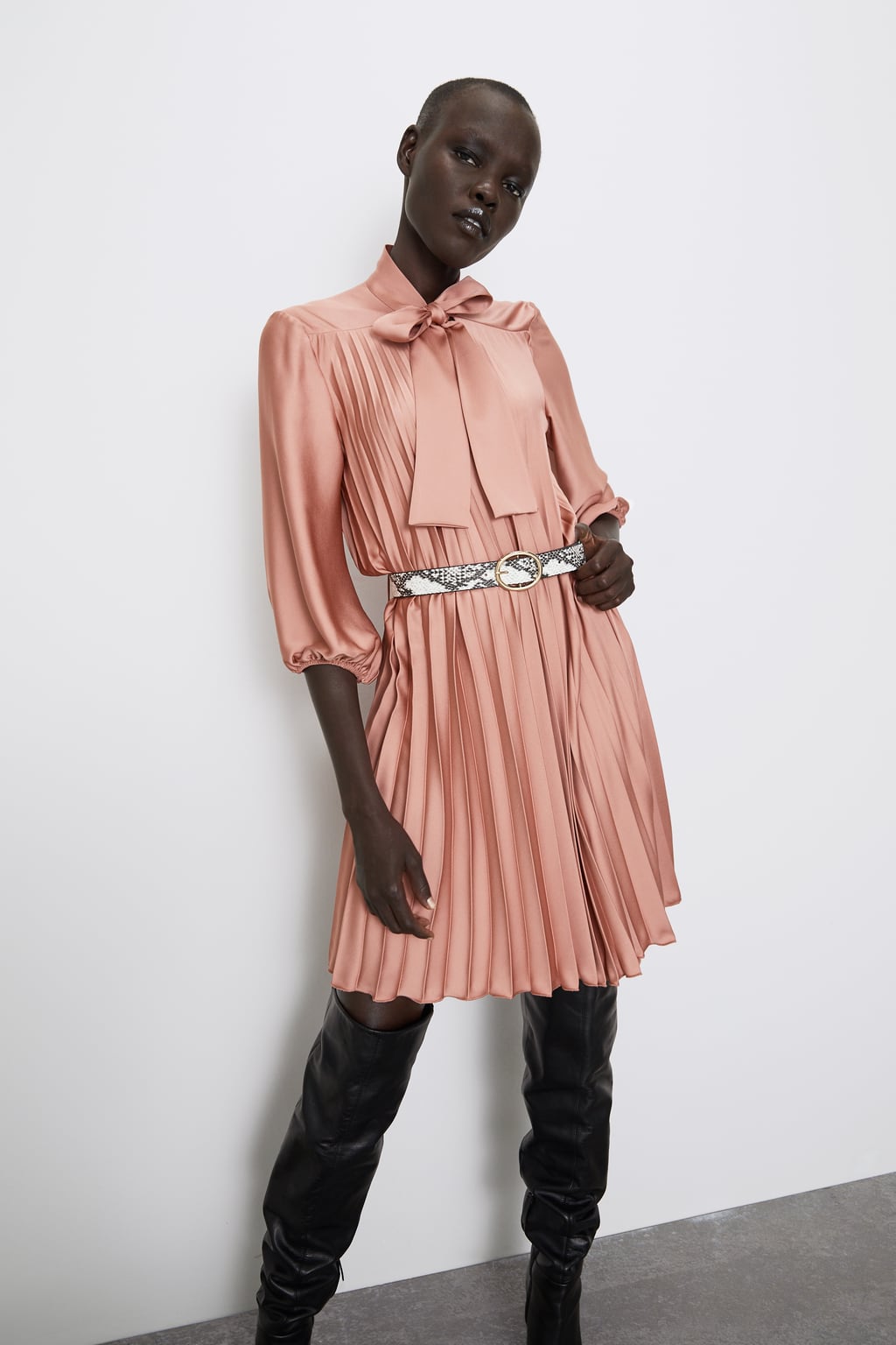 Vestido plisado rosa empolvado con cinturón de serpiente. ¡Ideal para combinar con tus botas XXL! (39,95 euros).