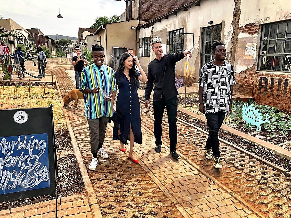 Sencillo, cómodo, estiloso y súper favorecedor, este look de Meghan Markle con vestido camisero midi abotonado en azul navy de Wilfred By Aritzia y bailarinas destalonadas en rojo de Everlane nos representa.