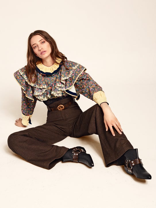 Blusa con volantes, pantalón, cinturón y botines, todo de Louis Vuitton.