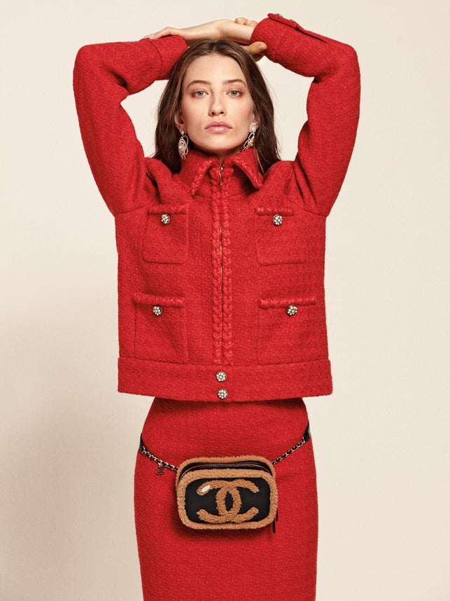 Traje de tweed, pendientes y riñonera, todo de Chanel.