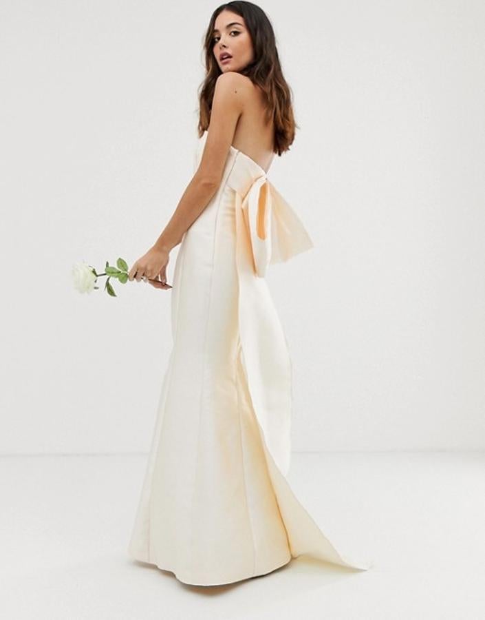 Las novias más clásicas encontrarán en este vestido de satén marfil con escote palabra de honor y maxi lazo a la espalda su mejor opción para una boda de cuento. Es de Asos y está rebajado a 145.99 euros.
