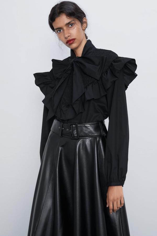 Blusa de cuello subido y manga larga, con volante y lazo en el mismo tejido en el delantero (Zara, 29,95 euros). Cierra en la espalda con una cremallera oculta en la costura.