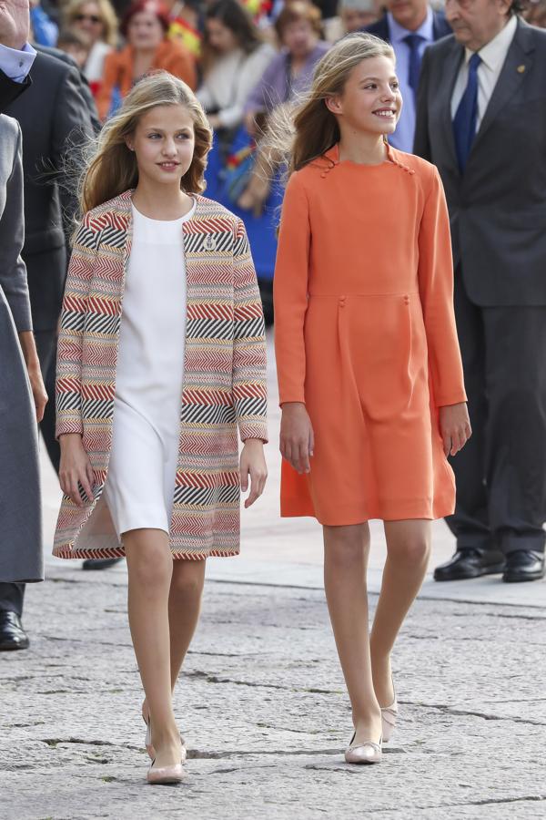Leonor y Sofía, que siempre se muestran muy cómplices en público, aparecieron con looks coordinados en los que el naranja fue el protagonista: en detalles del estampado en el abrigo de la Princesa, y pintando el vestido de la Infanta.
