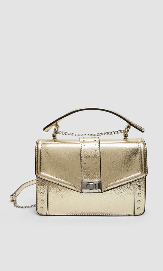 Si el dorado es tu color, esta bandolera con asa y cadena es el bolso que estabas buscando. Nos encantan los  remates circulares de los laterales  y su pequeño cierre, aunque es innegable que aún son más espectaculares en las versiones en negro y azul que también podemos encontrar por 17,99 euros.