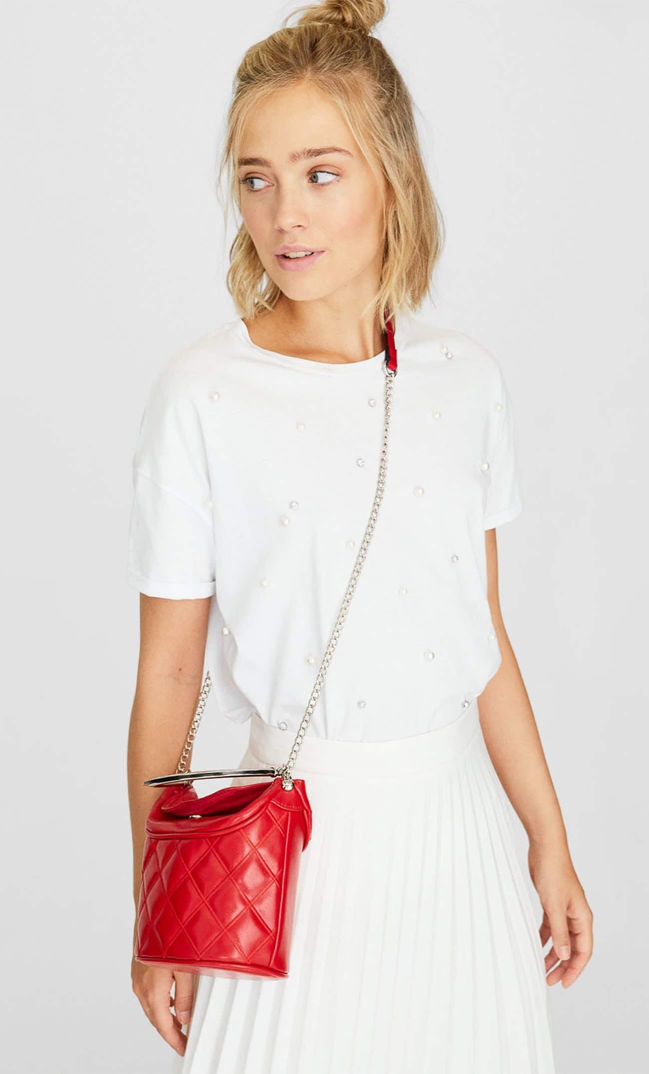 Con un  original diseño de bombonera , con cierre superior y asa metálica, esta propuesta es un 2x1 imprescindible sie el rojo es tu color fetiche. Cuesta 15,99 euros y también está disponible en negro.