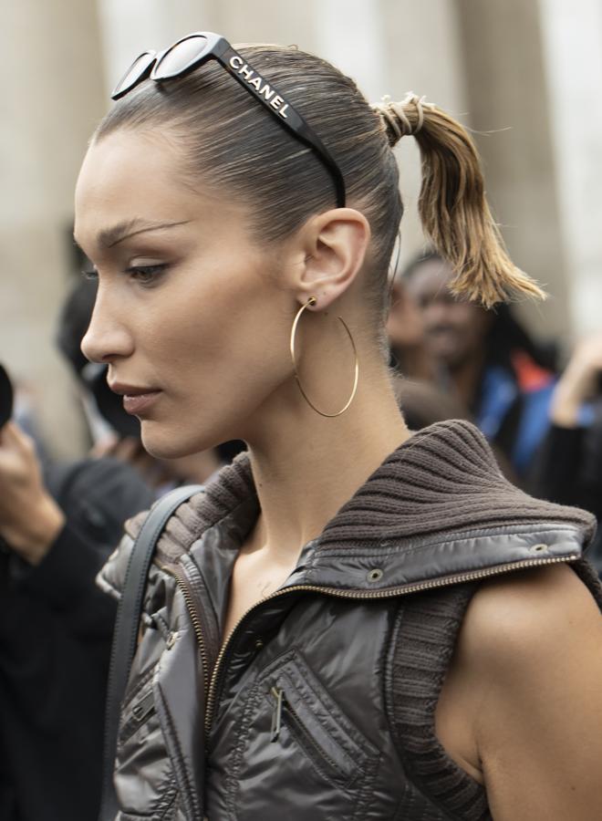 Una coleta nunca falla tengas el largo que tengas. Bella Hadid adora las mini para su nuevo corte de pelo. Pule bien todo tu cabello hacia detrás tensándolo lo máximo posible y peinándolo con un peine de púas muy finas. Después sujétalo con un coletero y adórnalo con una cuerda como la modelo.