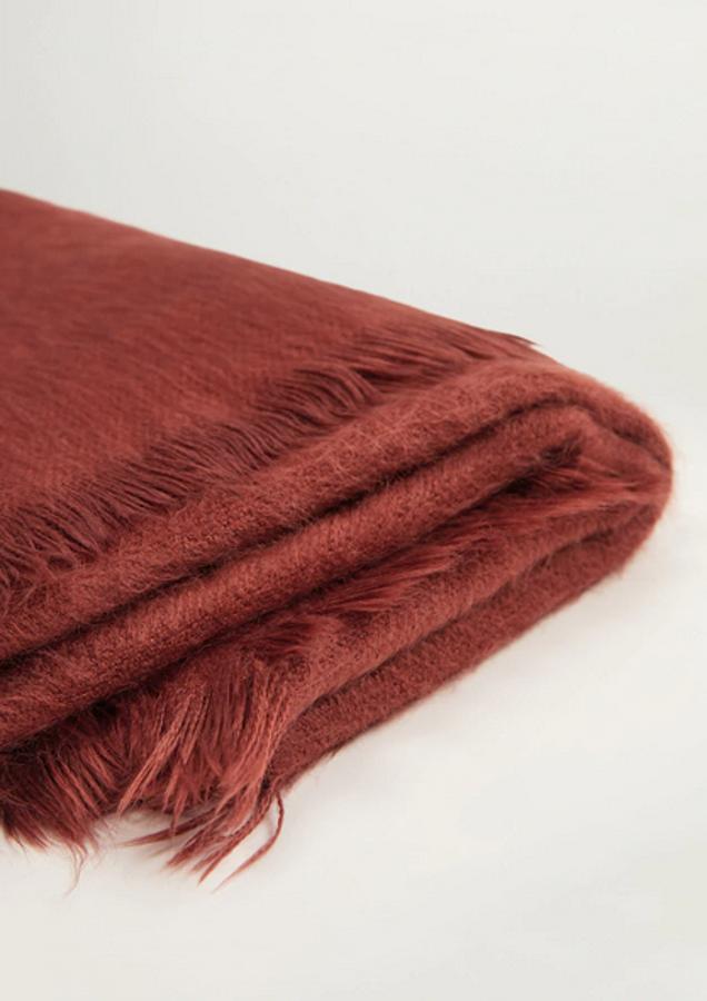 Son muchos los que han apostado por el efecto piel para confeccionar sus bufandas, pero pocos los que han conseguido un aspecto tan reconfortante como Mango con esta prenda de color rojo anaranjado. Cuesta 19,99 euros y también está disponible en color marfil.