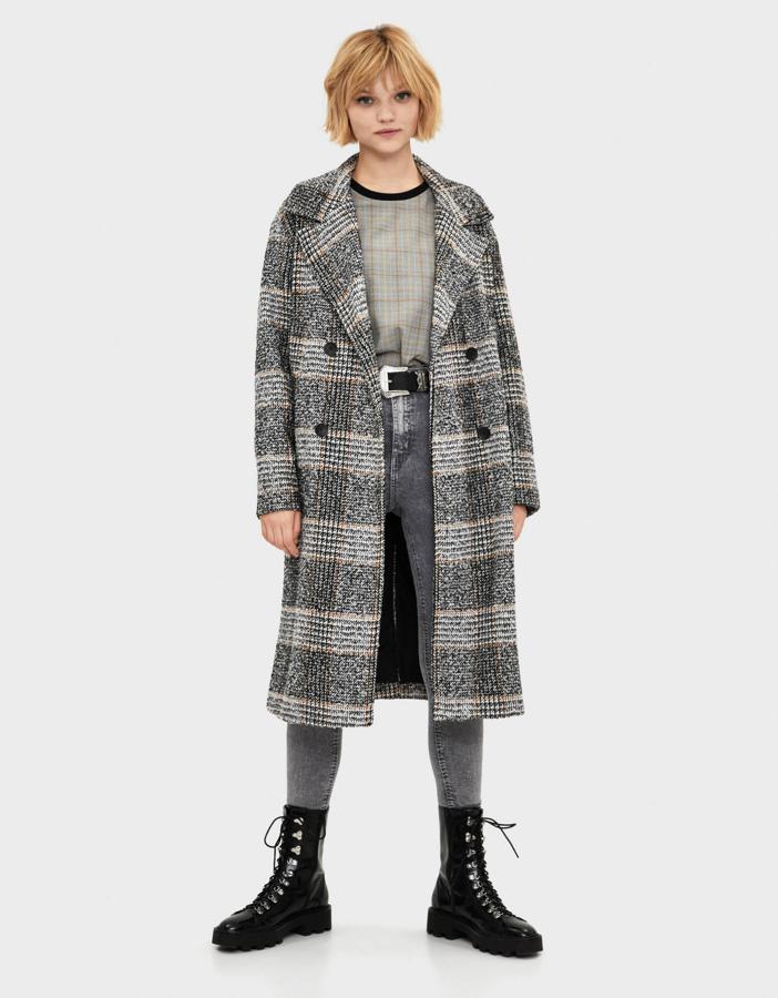 Los cuadros son una de las tendencias de este otoño/invierno y los abrigos también han querido sumarse a este estampado. Este de Bershka es una buena opción (59,99 euros).